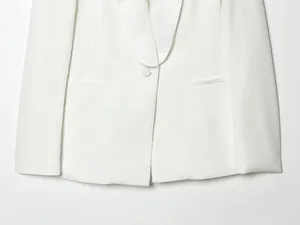 Close-up detail of an elegant white tuxedo collar blazer featuring a single button closure