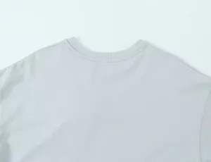 Detailed view of the ribbed crew neckline on a light grey asymmetrical t-shirt top