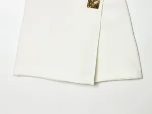Detailed view of white asymmetric skort featuring fabric texture and gold metal buckle