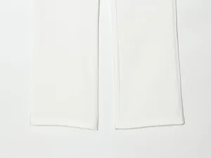 Close-up detail of white tuxedo trouser hems showing clean stitching and fabric texture