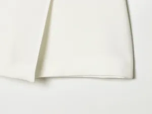 Close-up detail of white fabric texture on a trendy asymmetrical fashion skort.