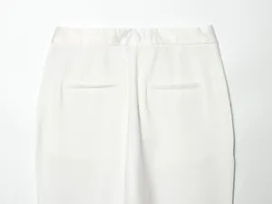 Detailed macro view showing the back pockets and waist of white tuxedo suit trousers.