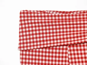 Close-up of red and white checkered fabric detail on high-waist pants for women
