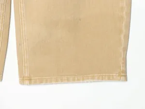 Gros plan sur l'ourlet d'un pantalon en denim kaki avec des coutures et bord brut
