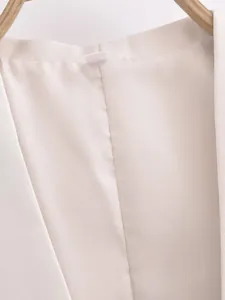 Détail de la doublure et du tissu d'un gilet de costume blanc sur cintre en bois