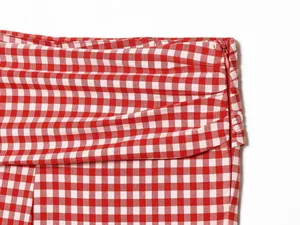 Macro view of red and white gingham fabric showing high-quality concealed side zipper detail