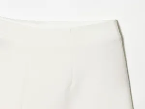 Close-up of white asymmetric skort waistband showing fine fabric texture.