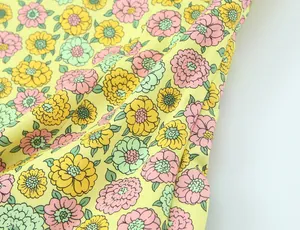Vue macro montrant la texture détaillée et l'imprimé floral jaune vif du tissu en popeline