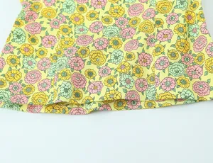 Vue macro détaillée montrant l'imprimé floral jaune vif sur un tissu en popeline doux