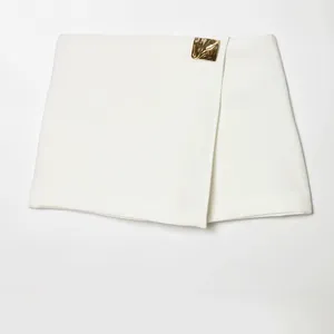 Fashionable white asymmetric wrap skort for women with gold-tone metal buckle detail