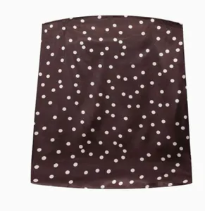 Détail d'un haut bustier en satin marron arborant un motif à pois blancs classique