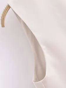 Gros plan d'un gilet de costume blanc montrant la texture du tissu et les coutures.