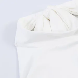 Close-up detail of a white halter neck dress featuring a stylish decorative knot