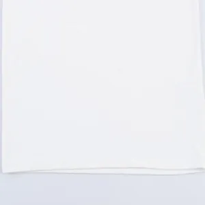 Detailed macro view of the clean hemline and soft white fabric texture of a dress