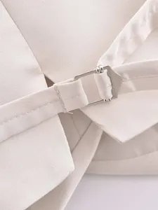 Vue détaillée de la boucle en métal argenté réglable sur un gilet de costume beige chic