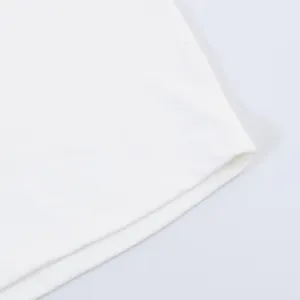 Close-up macro detail showing the high-quality hemline stitching on a white pleated dress