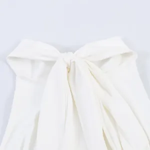 Detailed macro shot of the elegant pleated halter neck and bow knot on white dress