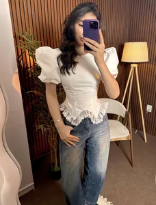 Full length view of a trendy white puff sleeve blouse with delicate lace hem trim.
