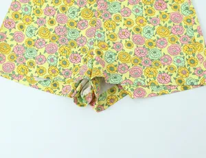 Vue détaillée d'un mini-short en popeline jaune à fleurs avec motif floral coloré