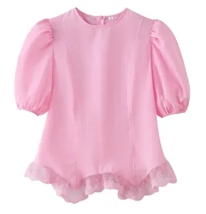 Close-up detail of a pink short sleeve puff top with delicate lace trim at the hemline