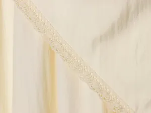 Detailed close-up showing the delicate lace trim on elegant cream beige midi skirt fabric texture