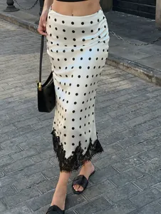 Detailed view of the polka dot midi skirt with black lace hem and elegant satin finish