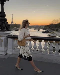 Detail of polka dot midi skirt with black lace hem against Paris sunset background
