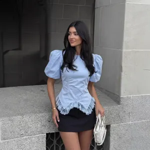 Elegant light blue puff sleeve top with delicate lace hem and stylish cinched waist design
