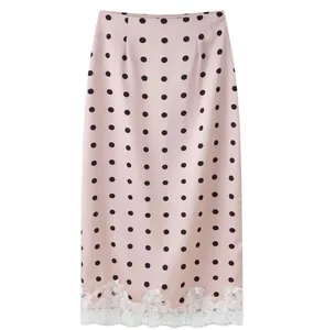 Close-up of pink polka dot midi skirt featuring elegant white lace patchwork at the hem