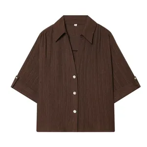 Detailed view of a brown textured short-sleeved shirt featuring a classic lapel collar