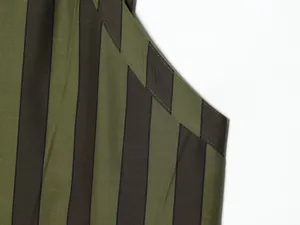 Close-up of olive green striped fabric texture and precision stitching on a two-piece set