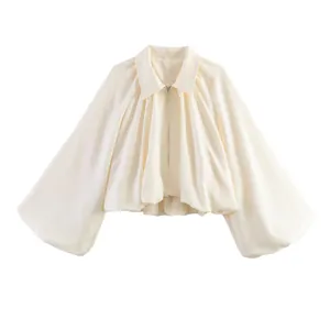 Détail d'une veste bomber courte de couleur crème avec manches ballon et fermeture éclair
