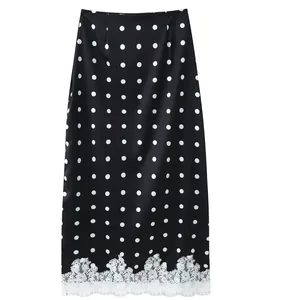 Detailed view of black polka dot midi skirt featuring white floral lace hem trim