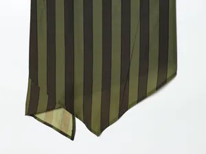 Macro detail showing the asymmetric pointed hemline of the olive and black striped top