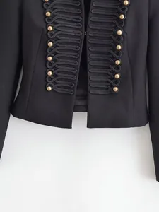 Close-up of black military blazer with gold buttons and braided cord embroidery.