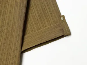 Close-up detail of textured olive green fabric with button and tab for women's set.