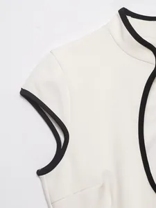 Detailansicht eines weißen Minikleides mit eleganter schwarzer Kontrastpaspelierung am Kragen.