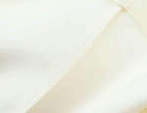 Macro view showing the neat stitching and soft fabric of this elegant white mini dress