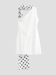 Close-up detail of a white halter neck dress with a stylish black and white polka dot scarf.