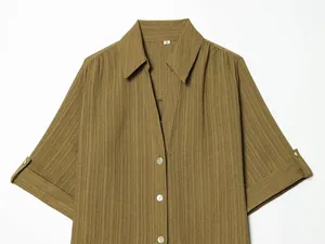 Macro view of the olive green textured short-sleeve shirt with collar and button details