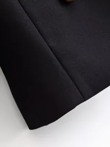 Close-up of black suit fabric showing fine diagonal weave and clean seam detail.