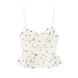 Close-up of a white camisole top featuring a sweet strawberry print and peplum hem.