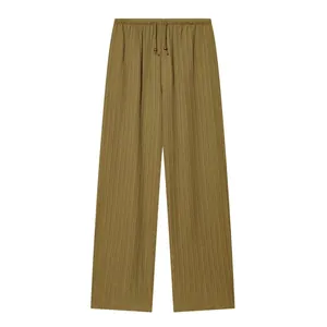 Detail view of khaki wide-leg pants with elastic drawstring waist and textured fabric