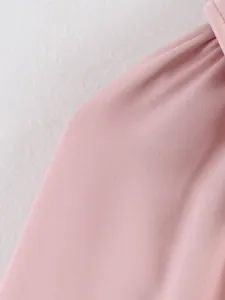 Gros plan détaillé montrant le tissu rose doux et la texture d'un blouson aviateur femme
