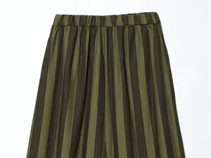 Close-up of vertical striped wide-leg pants with an elastic waist in olive and black.