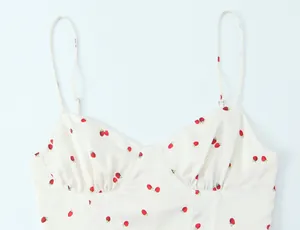 Detailed view of cream satin camisole top with small red strawberry print pattern
