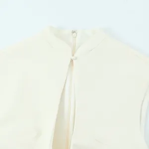 Close-up detail of elegant white sleeveless mini dress featuring stand collar and button