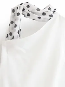 Macro detail of fashionable white dress featuring a stylish polka dot scarf neck design