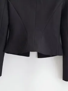 Close-up view of the back seams and tailored hem of a slim-fit black blazer jacket