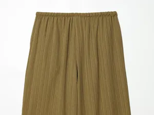 Detail of olive green wide-leg pants showing elastic waist and crinkle texture